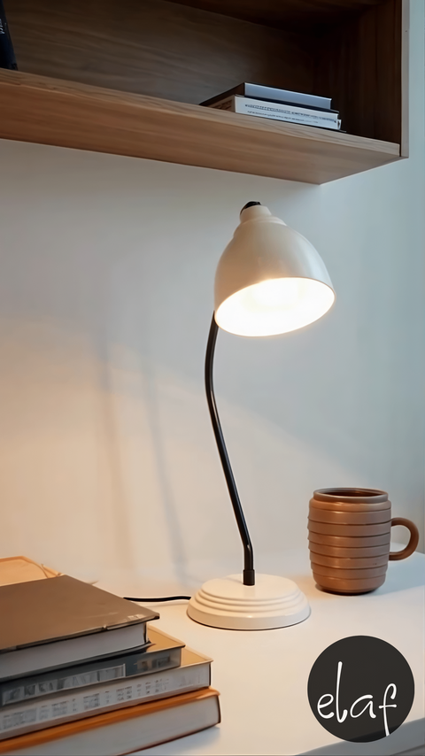 Vintage ivory white desk lamp with curved black arm and adjustable metal shade on round base, ideal for home or office use