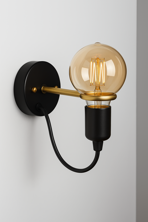 Modern wall sconce with matte black base and gold arm, exposed globe bulb and black cord mounted on wall