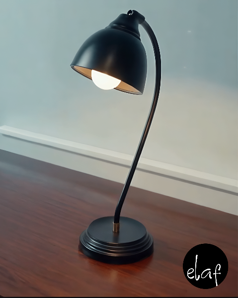 Matte black vintage-style desk lamp with curved metal neck and adjustable head, placed on wooden desk surface
