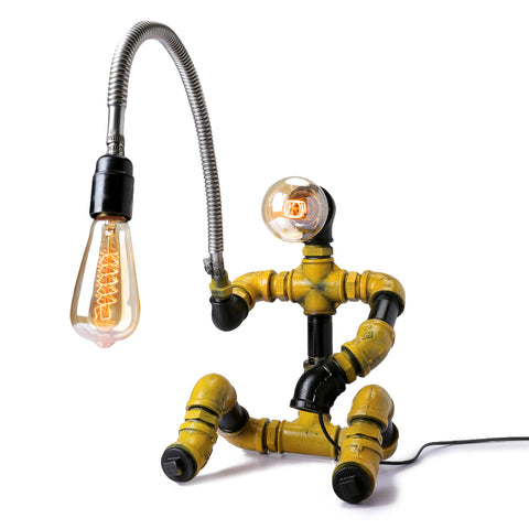 Industrial-style table lamp shaped like a fisherman holding a light bulb, made from metal pipework