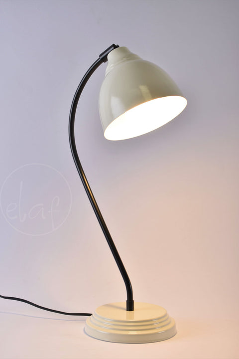 Vintage ivory desk lamp with curved black arm and adjustable metal shade on round base, ideal for home or office use