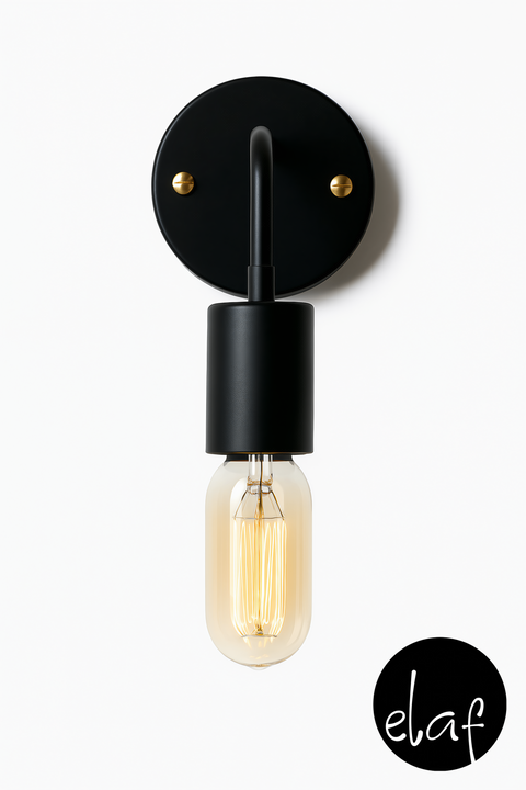 A black wall-mounted light fixture with a vintage bulb and gold accessories, designed in a modern style with a curved leg.